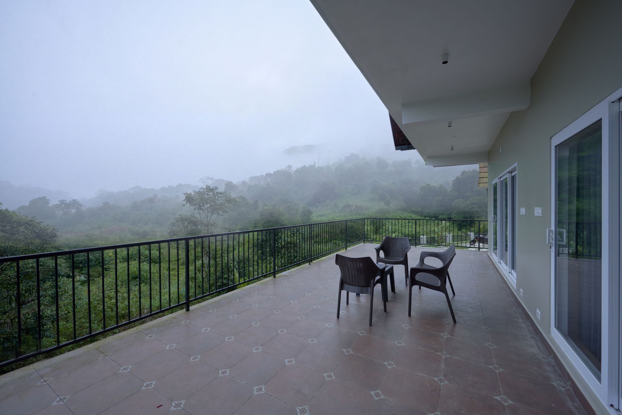 The Reach Vagamon — the balcony terrace looking over the valley in morning mist